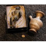 A small Mycenaean style pottery flask, a cast metal figure, a small carved stone and a string of