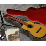 A Spanish six string guitar in hard carrying case, together with a music stand/foot rest.