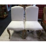 A pair of cream upholstered dining chairs on cabriole legs,53cm(W) 50cm(D) 96cm(H).