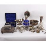 A collection of silver plated items to include cutlery, glassware topped with silver plate, napkin