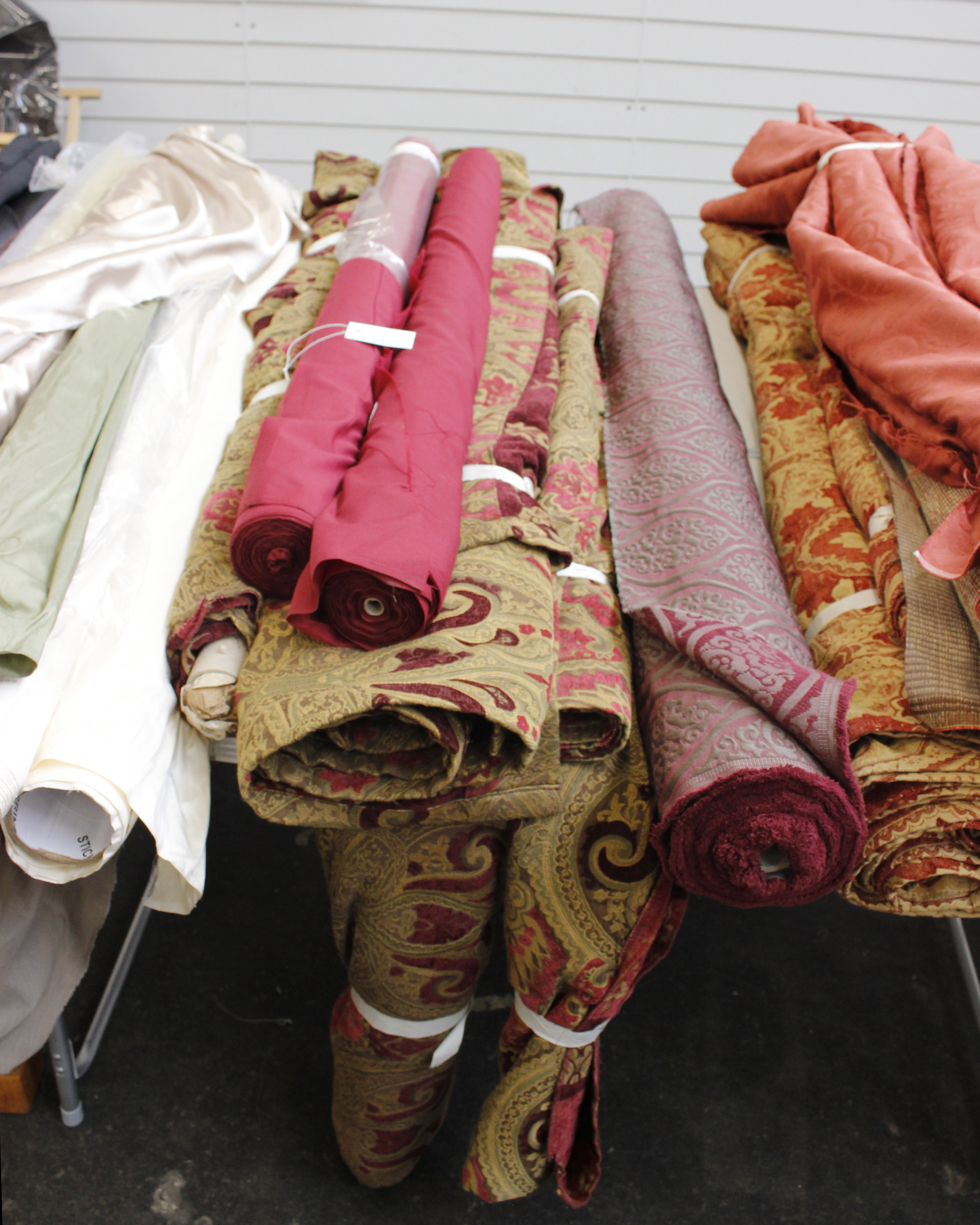 A large quantity of velvet brocade red, burgundy gold together with two rolls of burgundy poly