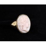 An 18ct gold coral cameo ring, the oval coral carved with a lady's profile, stamped 18 with full