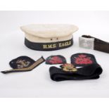 A H.M.S Eagle hat with four Navy cotton patches and a belt dated 1936 with a swastika belt buckle.