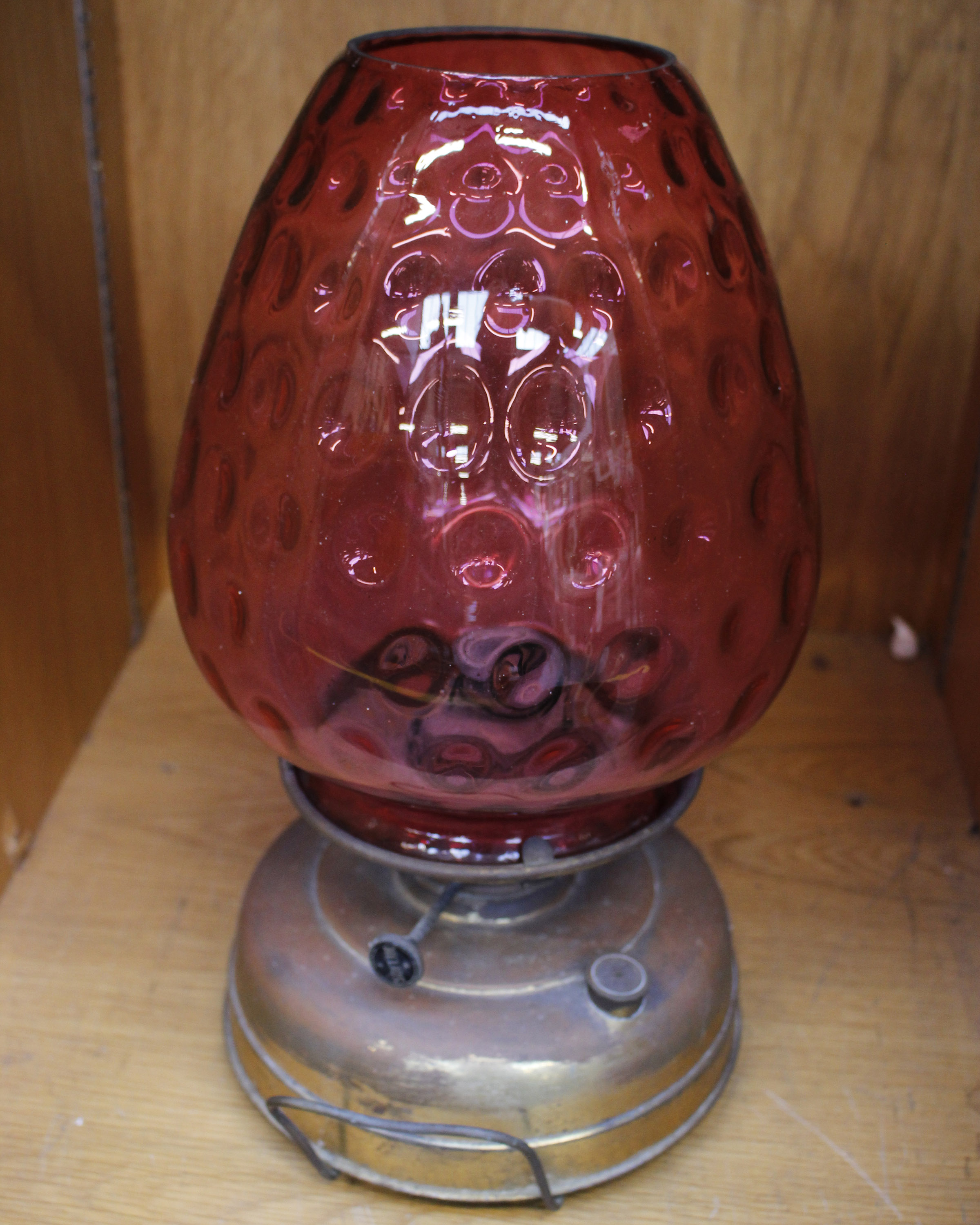 An Antique Metal Based Oil Lamp with Cranberry Glass Shade 43 cm high