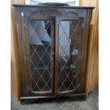 A 20th century astragal glazed oak corner display cabinet and an oak serving tray, carved details on