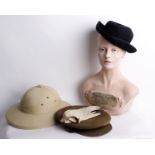 A vintage store mannequin head together with a selection of vintage military hats, vintage Pith