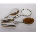 Hallmarked silver dressing table set with foliage stamped border comprising hand mirror, two brushes