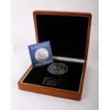 A sizeable 5oz pure silver £10 Britannia coin, issued by Tristan da Cunha, housed in a wood