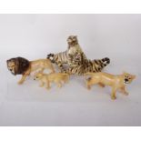 Three Beswick lions together with an unmarked statue of two fighting tigers