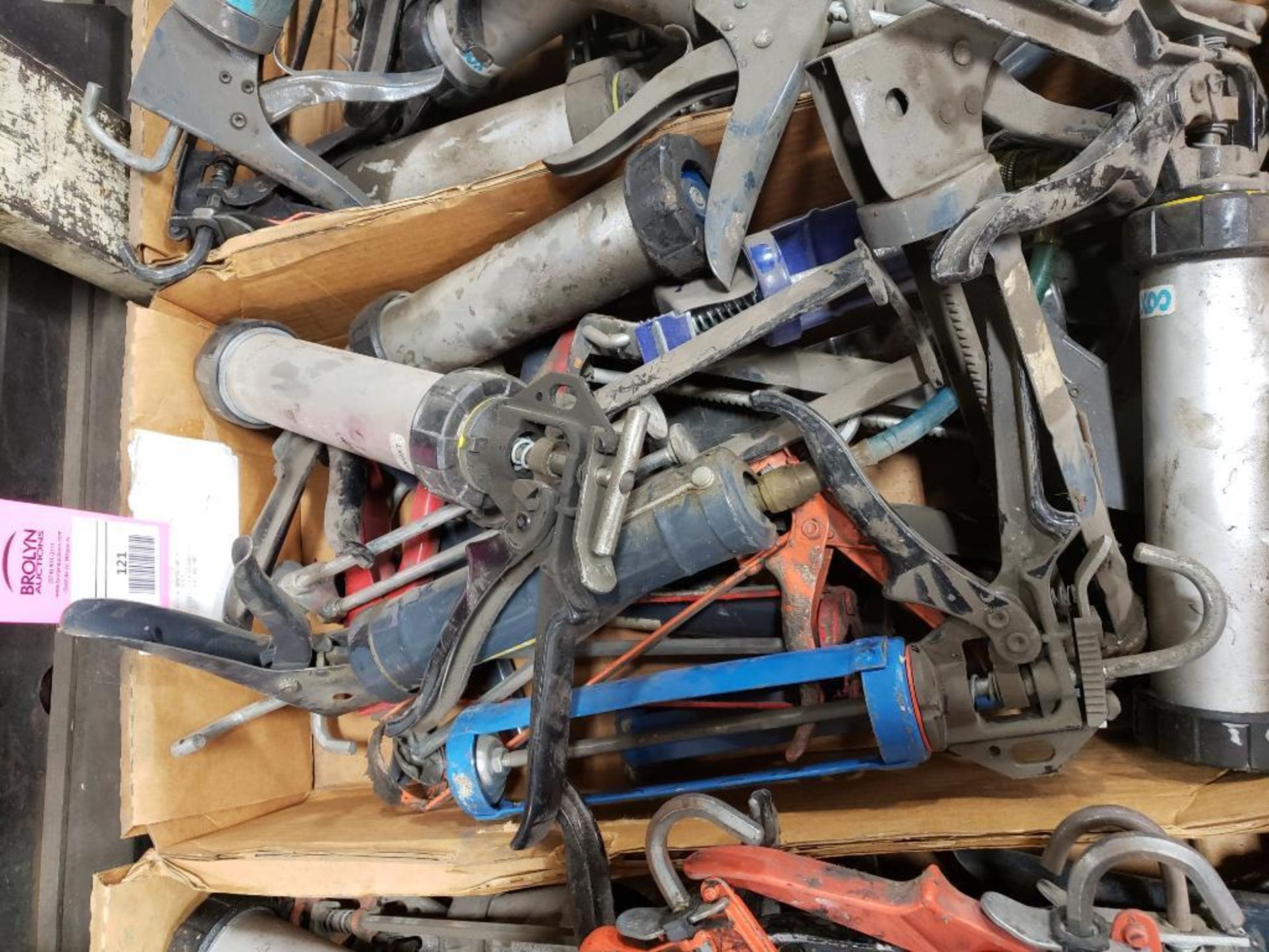 Large assortment of caulk and glue guns.