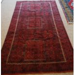 Blouch Rug, Decorated with allover geometric medallions on a red ground, 270cm x 150cm