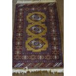 Turkman Prayer Mat, Decorated with three central geometric medallions on a red ground, 100cm x 65cm