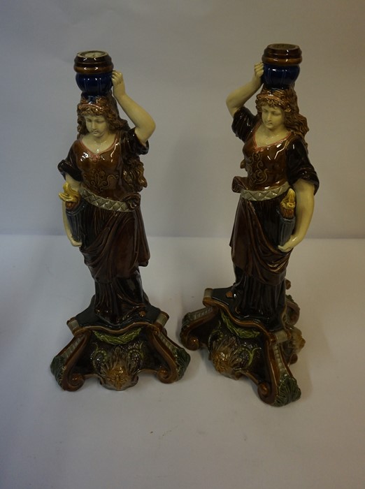 Pair of Majolica Candlesticks, Modelled as a female holding a torchere, decorated with masks, 45cm