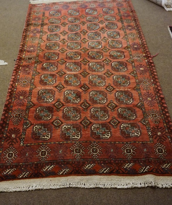 Turkman Rug, Decorated with allover rows of geometric motifs on a red ground, 212cm x 125cm