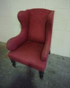 Upholstered Wing Armchair, raised on turned front legs with castors, 113cm high