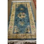 Chinese Rug, Decorated with allover floral medallions on a blue ground, 185cm x 90cm