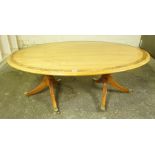 Walnut Coffee Table, Having an oval top, raised on two tripod pedestals, terminating on brass caps