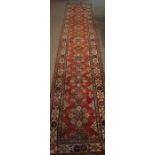 Kazak Runner, Decorated with allover floral medallions on a red ground, 380cm x 80cm