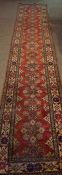 Kazak Runner, Decorated with allover floral medallions on a red ground, 380cm x 80cm