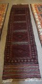 Afghan Runner, Decorated with five panels of geometric motifs on a red ground, 250cm x 63cm