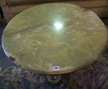 Onyx and Gilt Metal Coffee Table, Having a circular top, Raised on three gilt metal Nude male