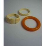 Two Ivory Coloured Bangles, Also with an amber coloured bangle, (3)