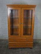 Modern Pine Display Cabinet, Having two Glazed Doors enclosing Glass Shelves above two Drawers,