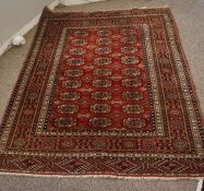 Turkoman Rug, Decorated with nine rows of three Geometric motifs on a red ground, 156cm x 125cm