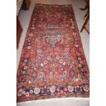 Persian Style Rug, Decorated with Geometric and Floral Medallions on a Red Ground, 303cm x 140cm