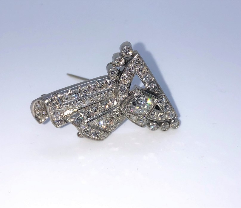 Art Deco Diamond Brooch, Of scrolling Ribbon form, Set with a single and round Brilliant cut