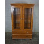 Modern Pine Display Cabinet, Having two Glazed Doors enclosing Glass Shelves above two Drawers,