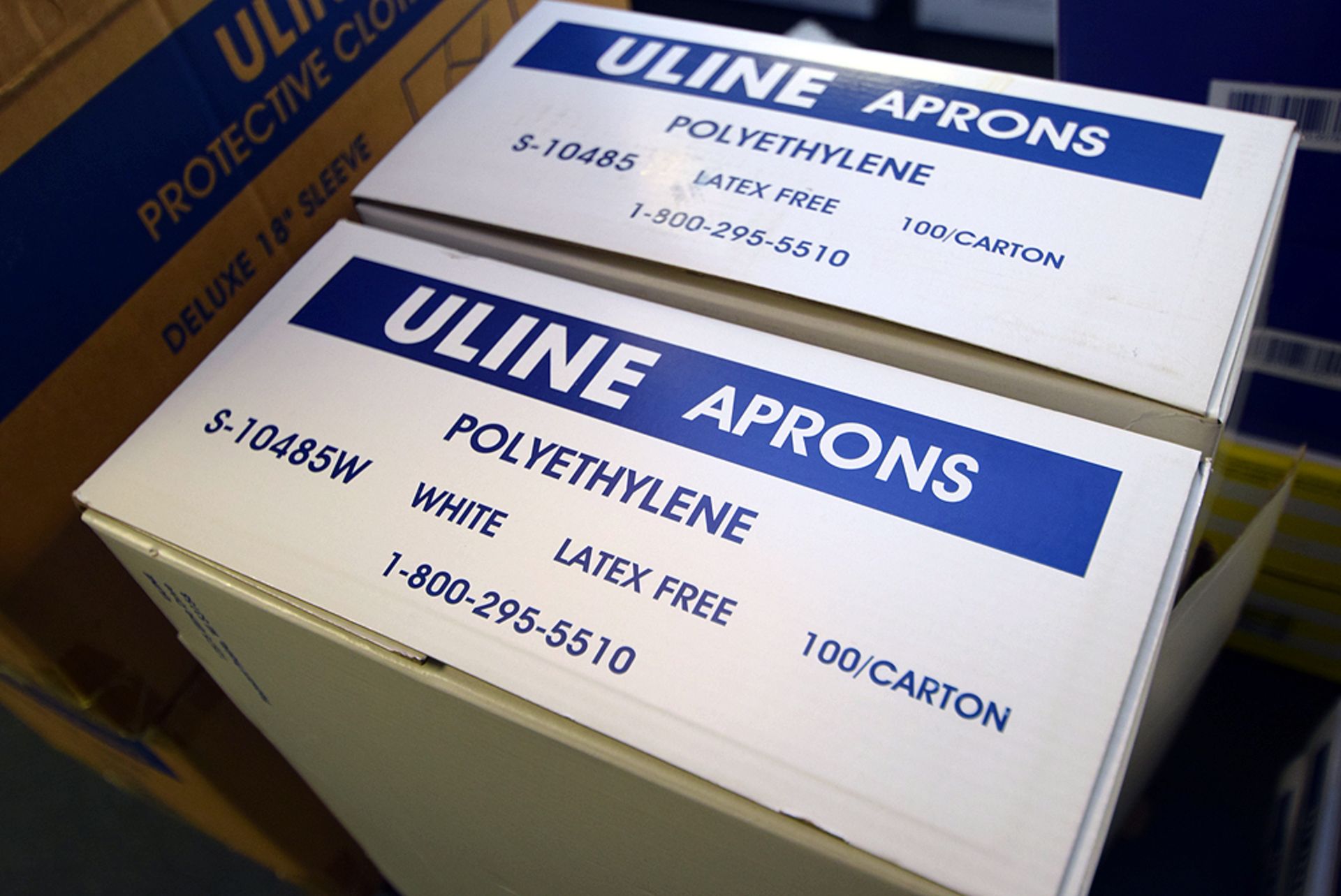 Boxes of Uline White Polyethylene Aprons