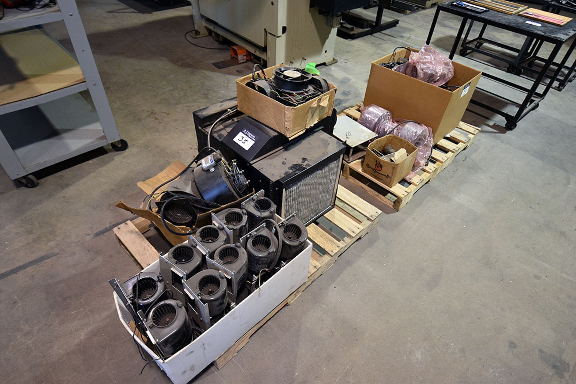 Pallets containing assorted machine parts, blowers, fans, and etc.