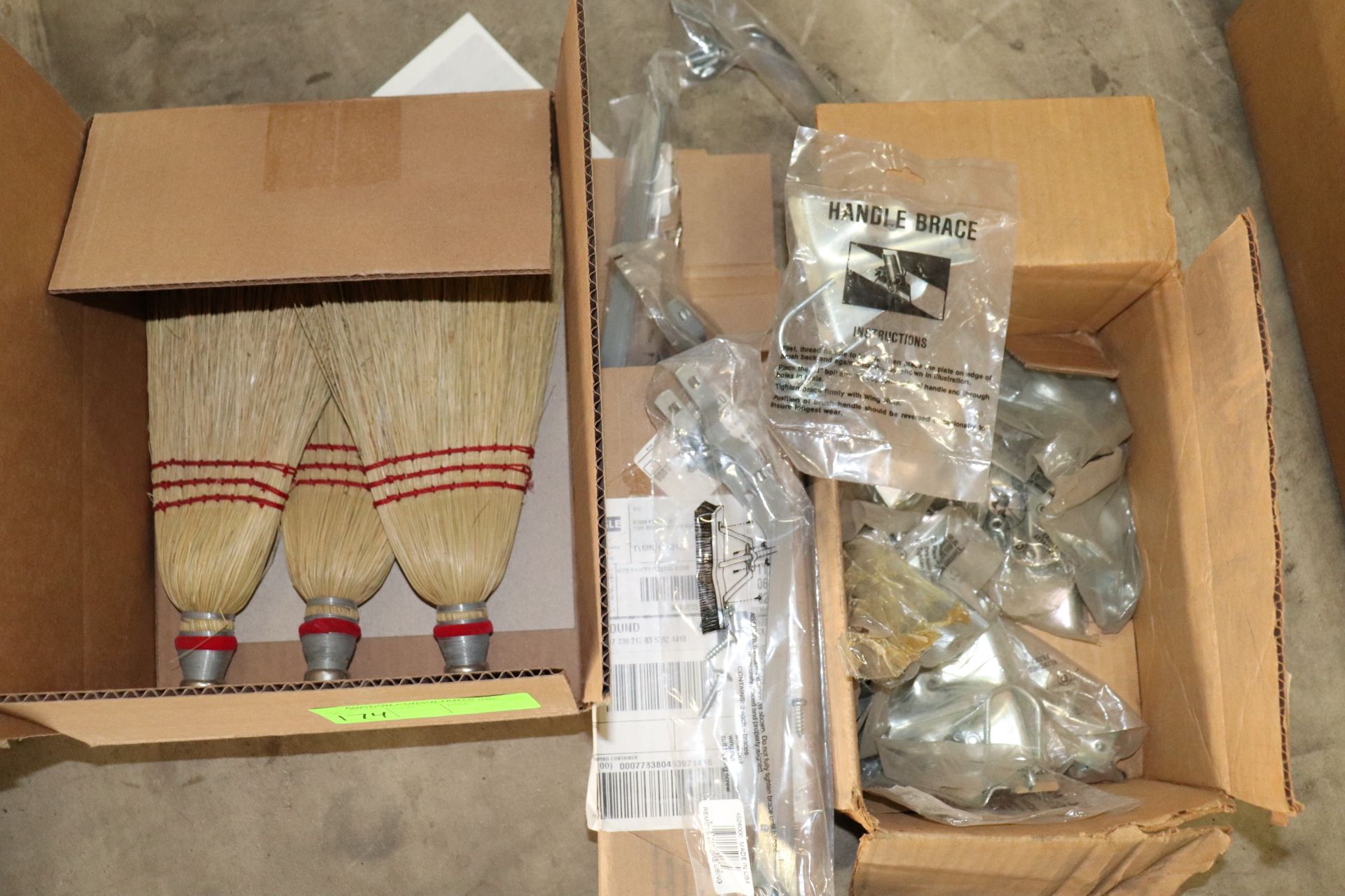 Group of whisk brooms, broom brackets and assembly pieces