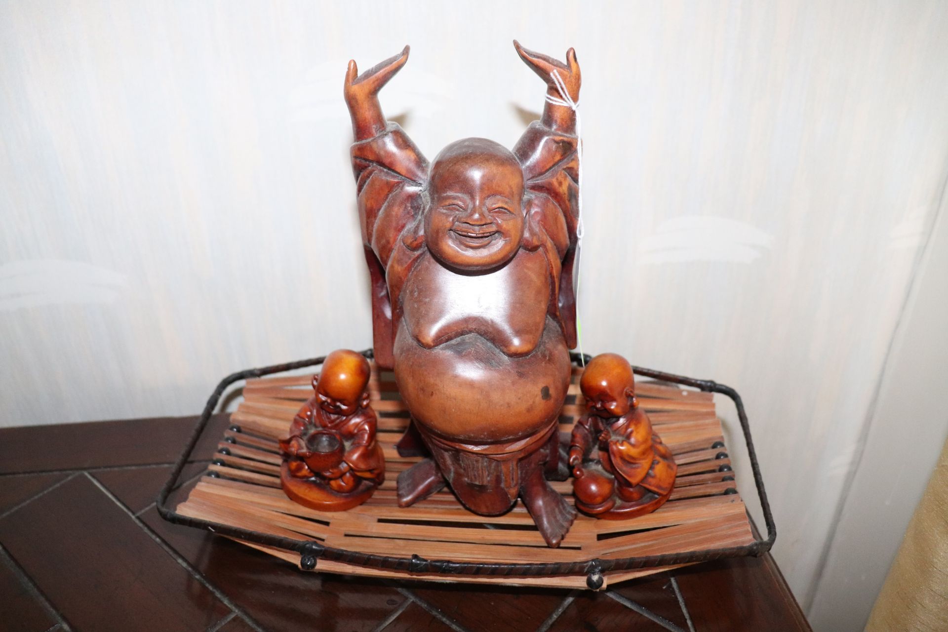 Carved wood Buddha, height 10", with two minor figurines and a wicker tray