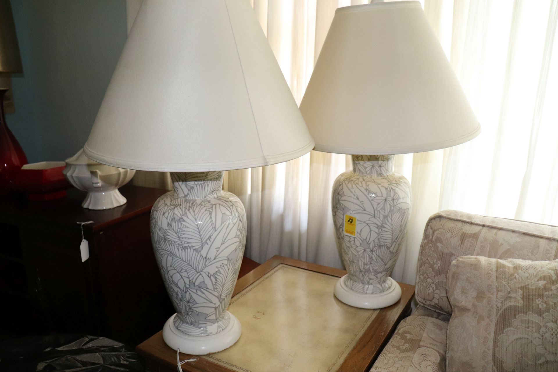 Pair of white and gray floral and leaf design porcelain table lamps each fitted with a beige shade,