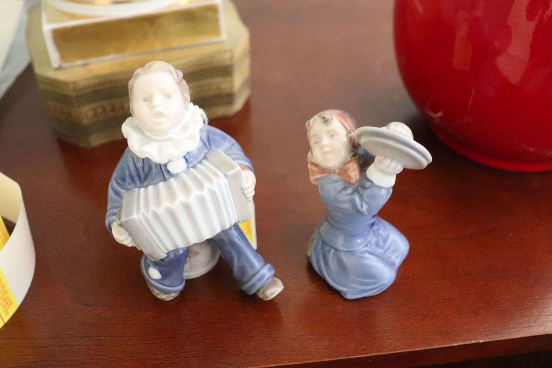 Pair of Royal Copenhagen figures, one of a boy playing accordion and one of a girl playing cymbals,