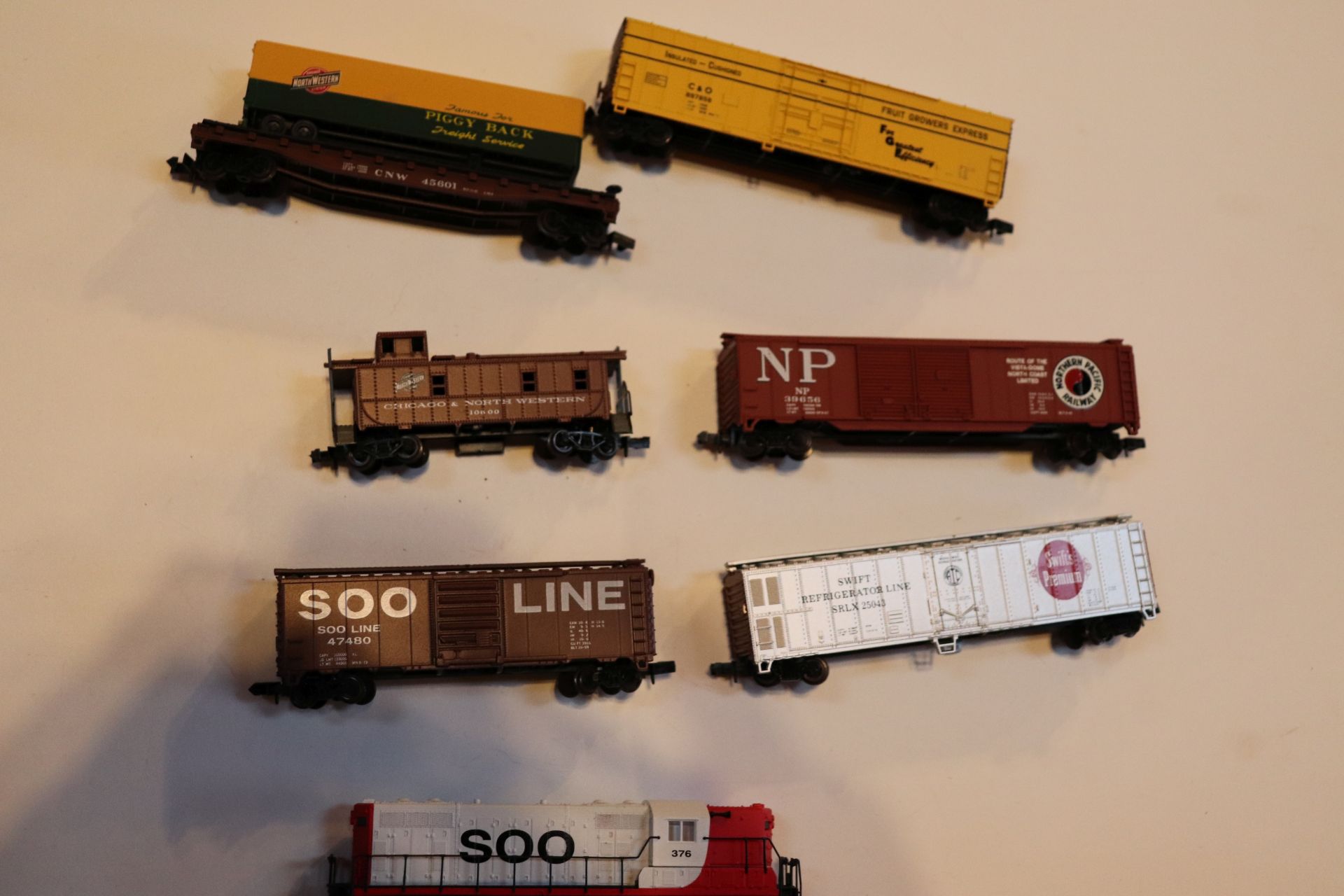 Six train cars, Atlas and others, and one Atlas locomotive, N scale
