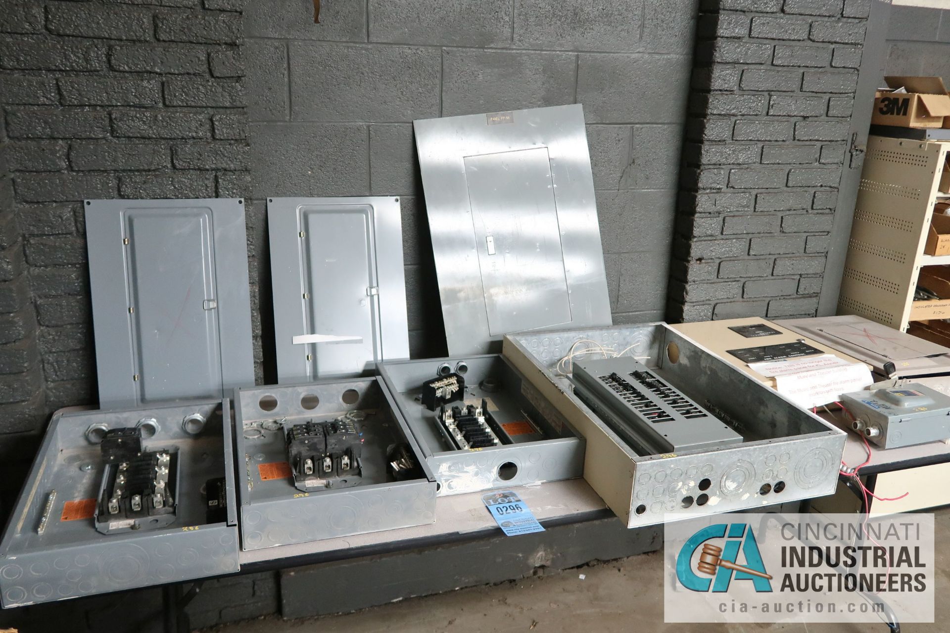 (LOT) ASSORTED ELECTRICAL ALONG THE WALL - TABLE WITH SERVICE PANELS BY SQUARE D, SHELF UNITS WITH