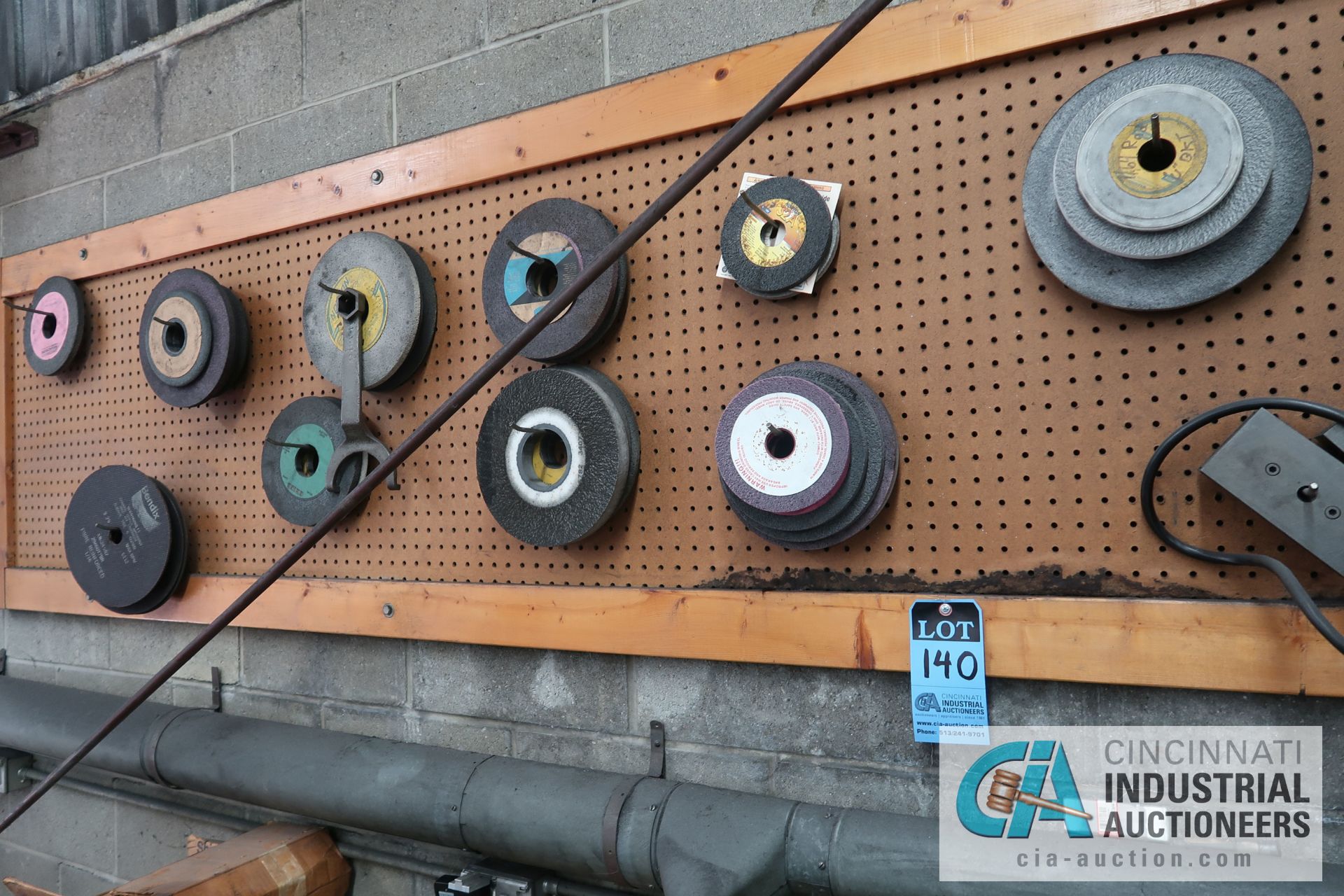 (LOT) MISCELLANEOUS GRINDING WHEELS ON WALL AND BENCH **PEGBOARD STAYS WITH BUILDING**