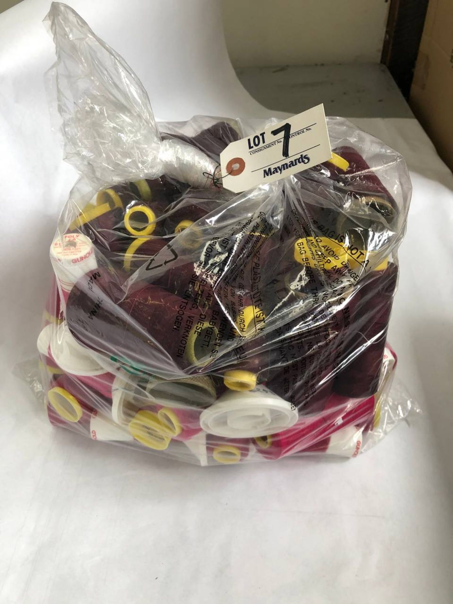 Bag of assorted burgundy colored thread rolls