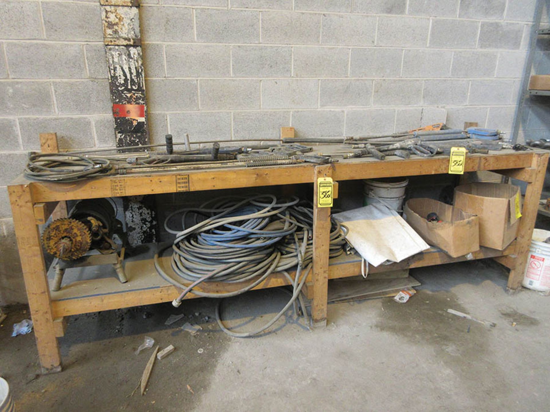 (2) SHELF UNITS W/ COUPLINGS, HANGERS, WORKBENCH W/ GARDEN HOSE, AIR HOSE, AND ASSORTED PRESSURE