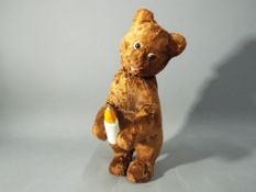 A mid 20th century Russian clockwork bear with brown fur and drinking action.