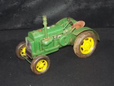 A tin plate model of a Farm Tractor, measuring approximately 30cms in length. The model is unboxed.