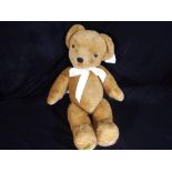 A 26 inch Merrythought Classic bear in golden brown with original tags and wrapper.