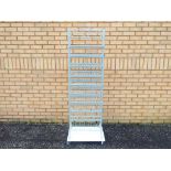 An unbranded grey metal shop display stand with 10 fixed metal shelves mounted on castors The