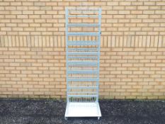 An unbranded grey metal shop display stand with 10 fixed metal shelves mounted on castors The