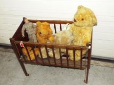 A scratch built wooden childrens cot with a Burbank Teddy Bear plus two other modern bears,