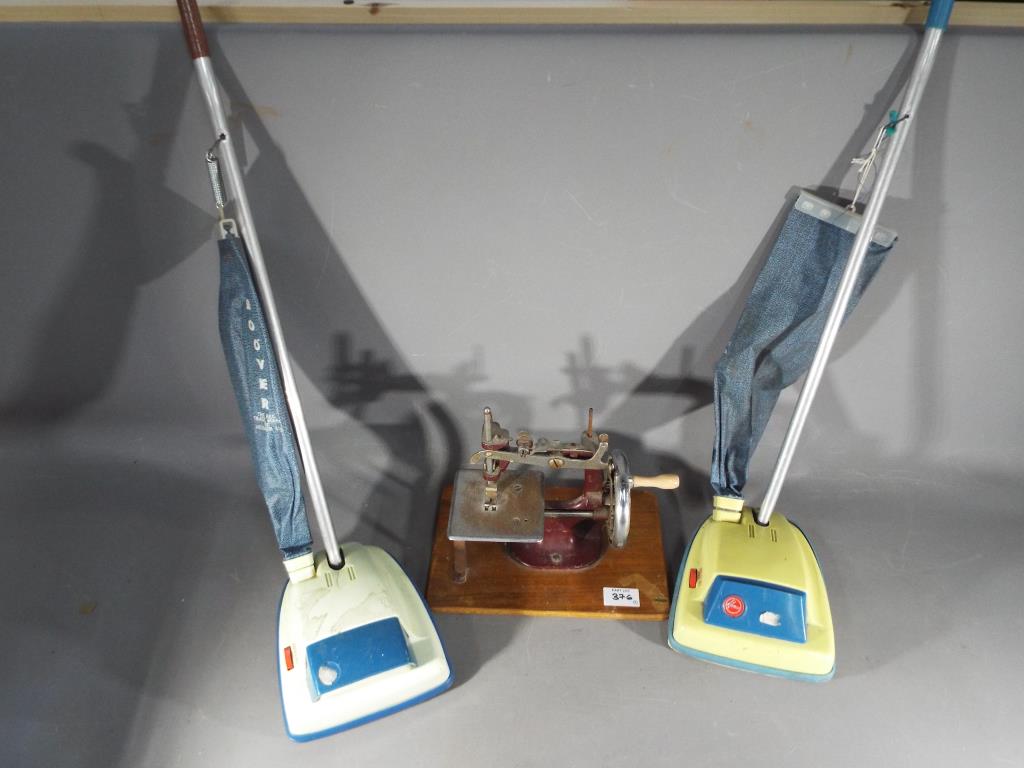 Two C.M.T Wells Kelo Ltd miniature Hoover Juniors and a child's sewing machine.