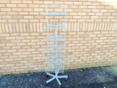 A wire, revolving retail shelving stand on castors,